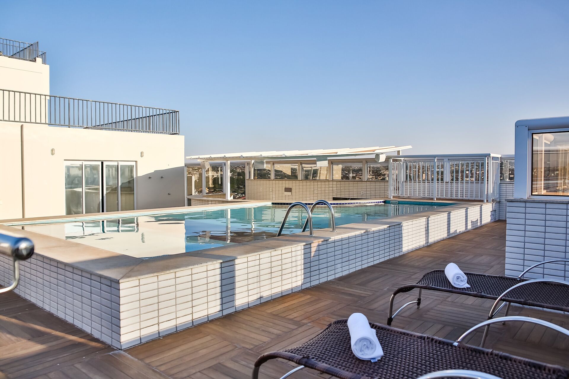 outdoor pool, a rooftop pool, open 7:00 am to 10:30 pm, pool loungers