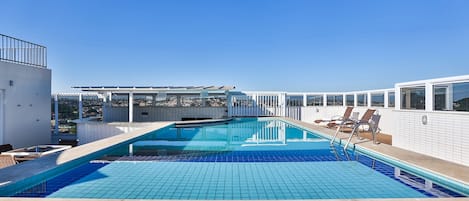 Piscina all'aperto, una piscina in terrazza, lettini