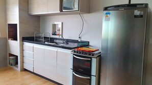 Eine moderne Küche mit eingebauter Mikrowelle, einem Kühlschrank und einem Doppelbackofen.