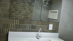 Ein modernes Badezimmer mit Waschbecken, Spiegel und einer strukturierten Wand.