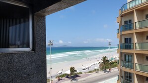 Vista de una playa desde un edificio con ventana que da al océano.