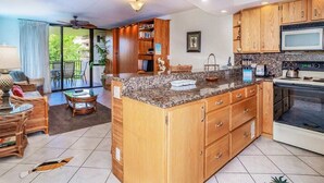 Eine geräumige Küche mit Holzausstattung, einer Granitarbeitsplatte und einem eingebauten Backofen.