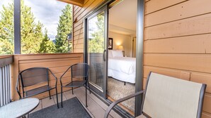 A balcony with two chairs and a table, a bed with white bedding, and a view of trees and mountains. - Two Private Balconies w/ Beautiful Views & Short Walk to Lifts, Shops, Dining (Keystone)