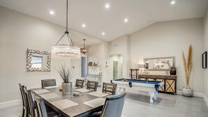 A dining area with a pool table, a chandelier, and a large mirror. - Recently Renovated Luxury Home in Grayhawk (Scottsdale)