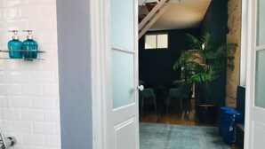 A bathroom with white tiles, a shower, and a shelf with blue bottles. - ★ Romantic - Casa Bela ★ Penthouse with views (Porto)
