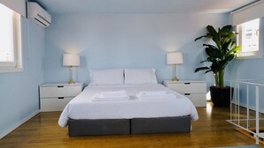 A hotel room with a large bed, two bedside tables, a potted plant, and a view of the city. - ★ Romantic - Casa Bela ★ Penthouse with views (Porto)