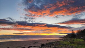 A beach with a sunset and clouds. - Ohope Beach Motel (Ohope)
