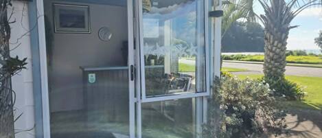 A glass door entrance with a clock and a small framed picture on the wall.