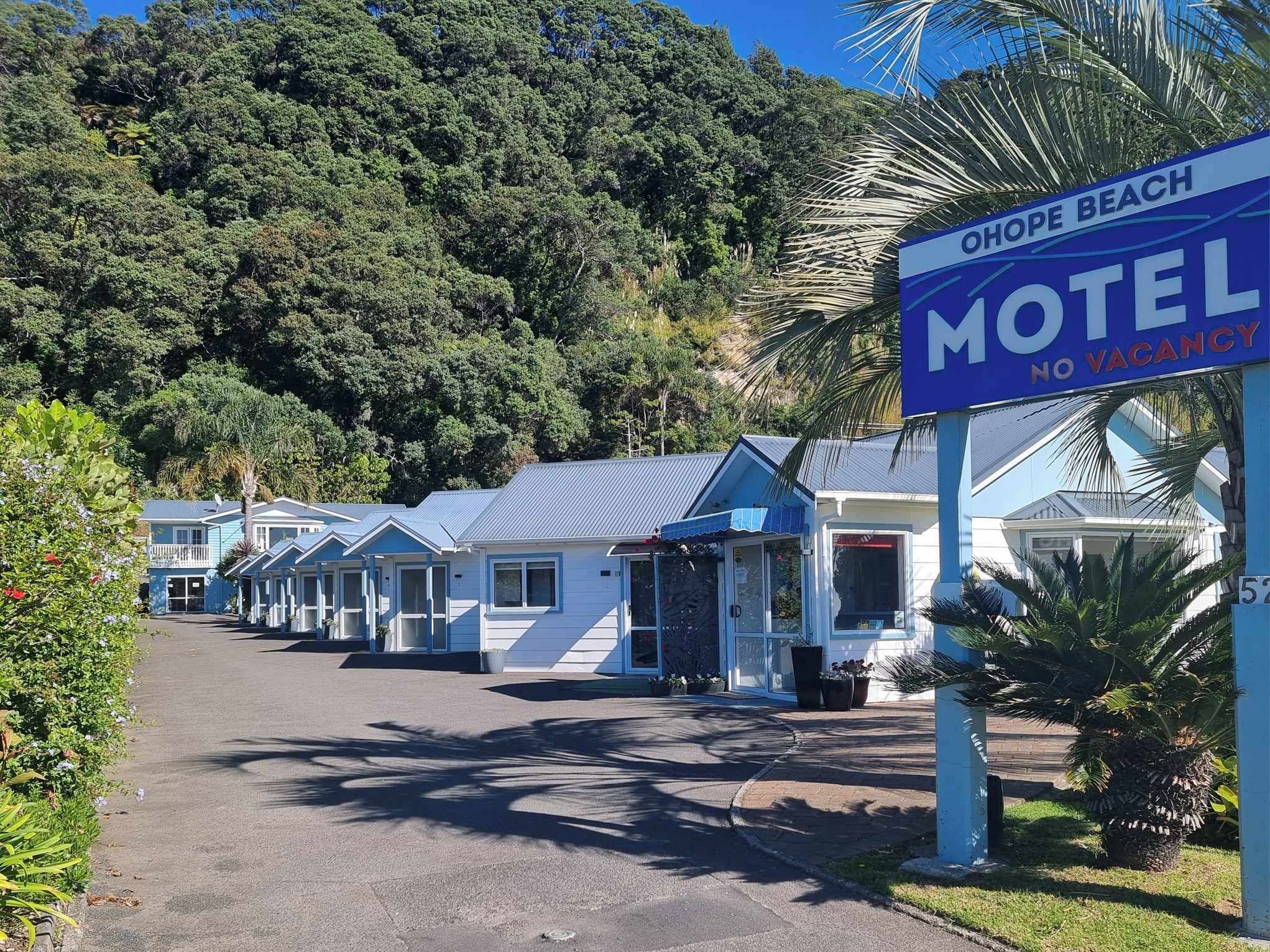 Una fila di edifici motel con un cartello che indica 'nessuna camera disponibile'.