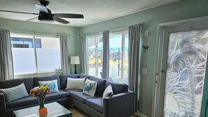 A living room with a grey sectional sofa, a coffee table, and a ceiling fan. - Luna Azul, only steps to Mission Beach! Free Wireless Internet / NO SMOKING (San Diego)