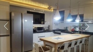 A modern kitchen with a central island, stainless steel appliances, and pendant lighting. - Sudabang Guesthouse - Hostel (Mokpo)