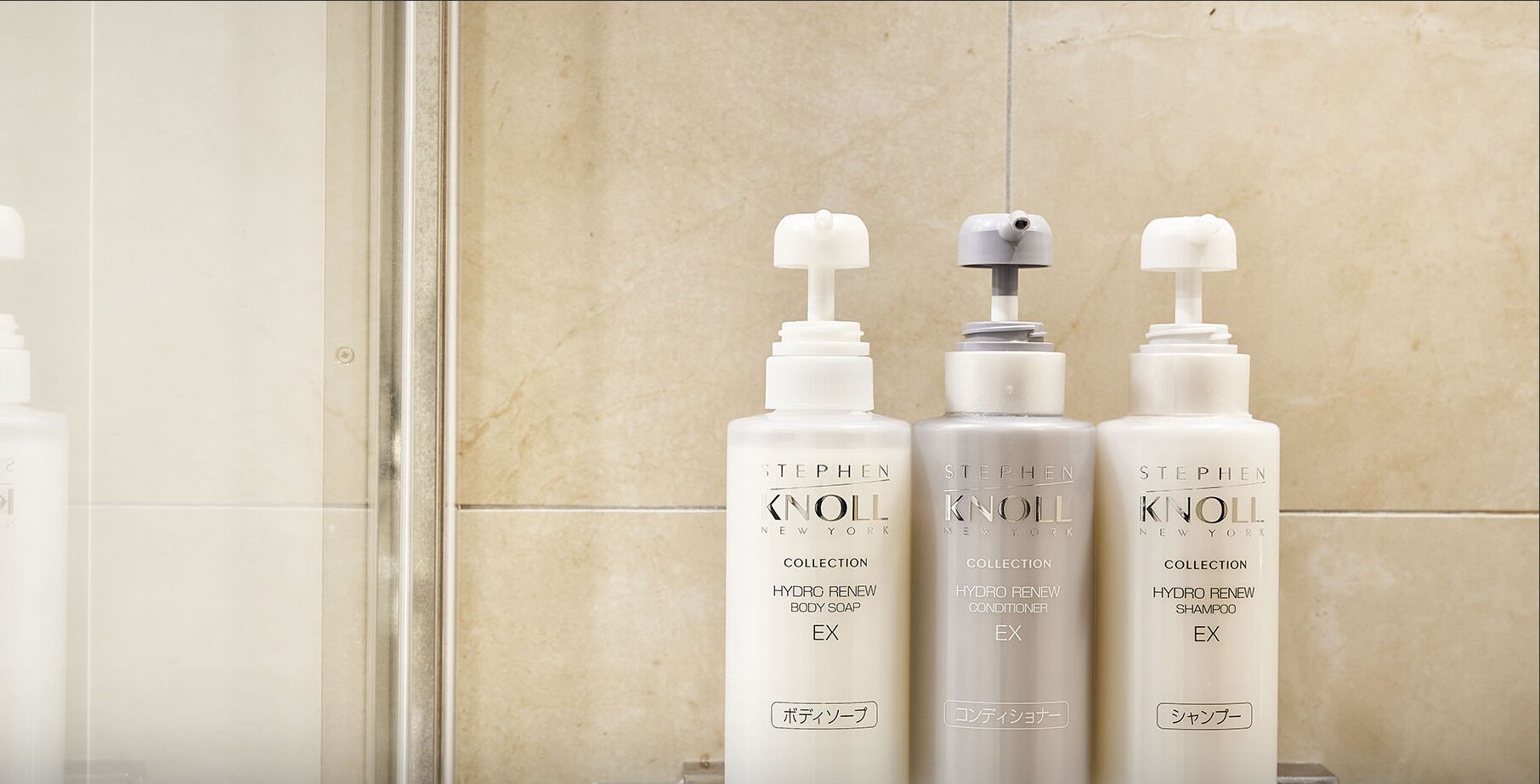 Tres botellas de la colección Stephen Knoll sobre una encimera de baño.