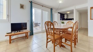 Un appartement moderne comprenant un coin repas, un téléviseur et une cuisine.
