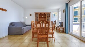 Un salon comprenant un canapé, une table à manger, des chaises et un buffet en bois.