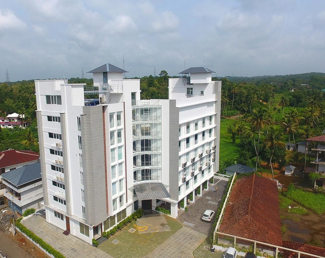 A modern multi-story building with a flat roof and large windows.