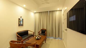 Luxury Studio Suite | Living room | 40-inch LED TV with cable channels, TV
