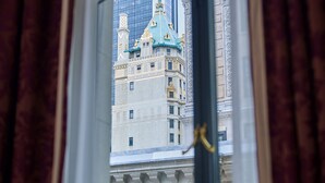 A window view of a historic building with ornate architecture, a balcony, and curtains. - 5th & 55th Residence Club (New York)