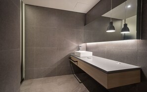 A modern bathroom with a rectangular sink, a mirror, and pendant lighting. - H hotel (Seoul)