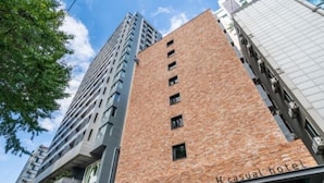 A tall building with a brick facade and a sign reading "Casual hotel" on the ground floor. - H hotel (Seoul)