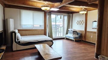 A wooden cabin-style room with a bed, bench, and a view of the outdoors.