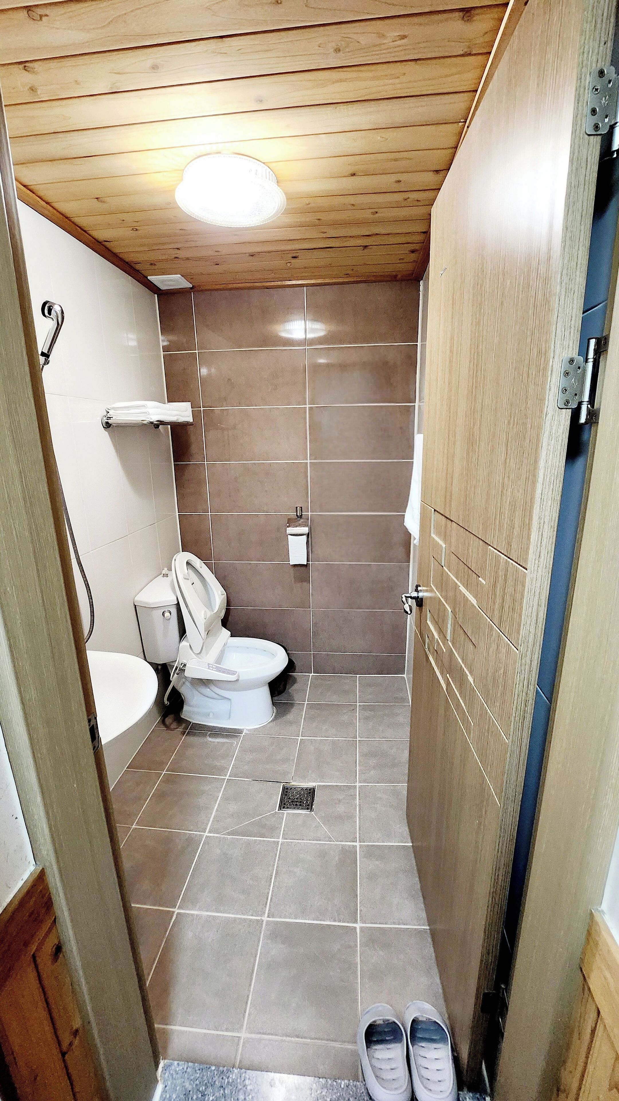 A small bathroom with a toilet, sink, and shower.