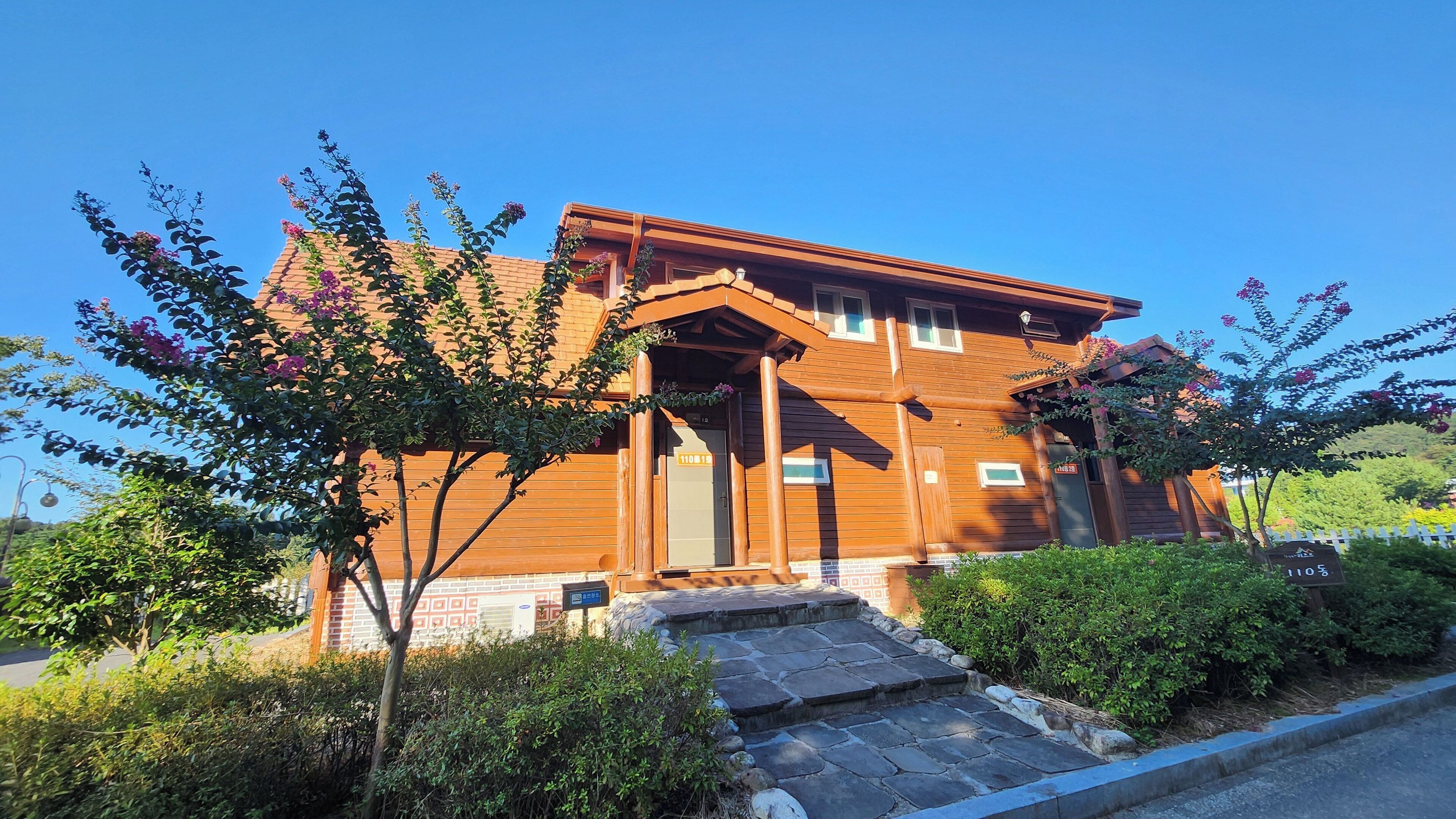 A wooden building with a stone entrance and a small porch.