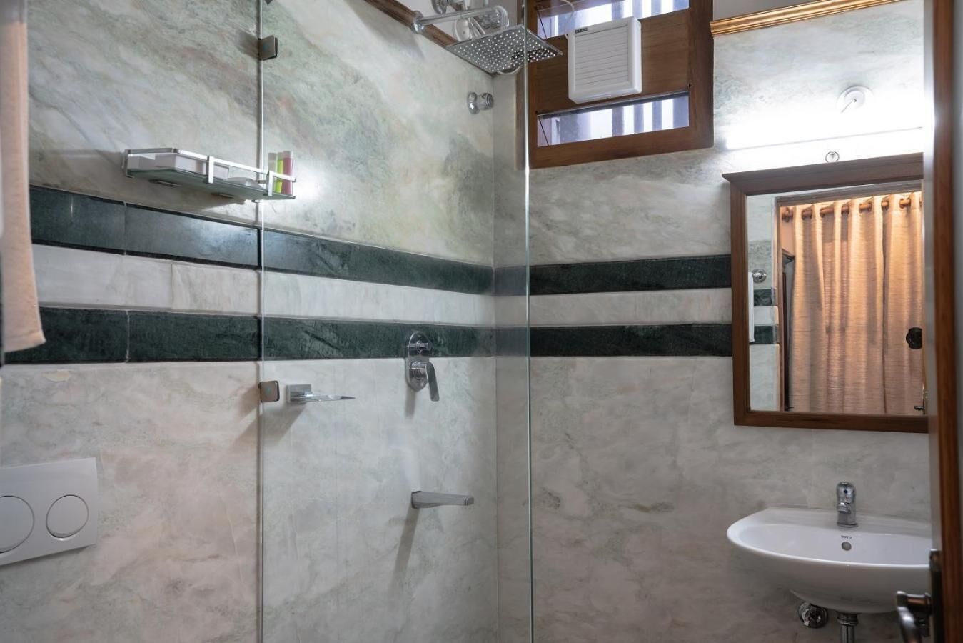 A bathroom with a glass shower enclosure, a sink, and a mirror.