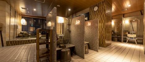 A modern bathroom with a wooden ceiling, tiled floor, and a large mirror.