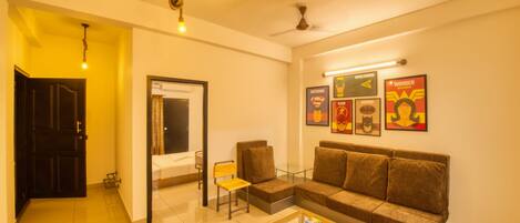 A living room with a sofa, coffee table, and wall art.
