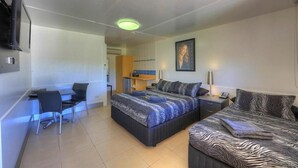 Een slaapkamer met een bed, een bureau en een stoel.