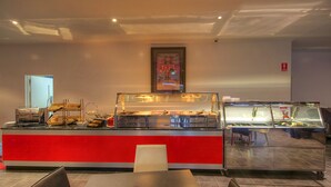 Een buffetgedeelte met een rode toonbank en glazen vitrines.