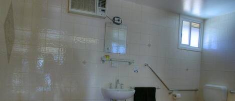 A bathroom with a bathtub, sink, toilet, and a window.
