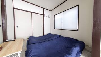 A bedroom with a bed, a small table, and a wardrobe.