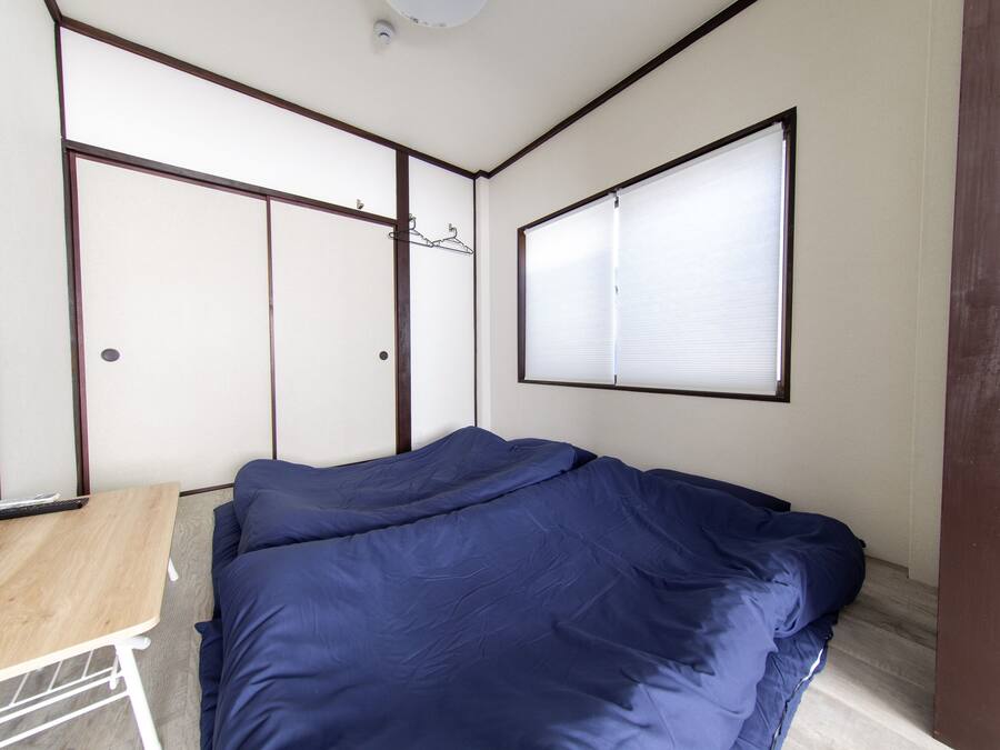 A bedroom with a bed, a small table, and a wardrobe.