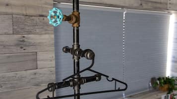 A metal pipe with a blue valve and a black hanger.