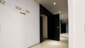 A hallway with a directional sign indicating room numbers 103 to 107.
