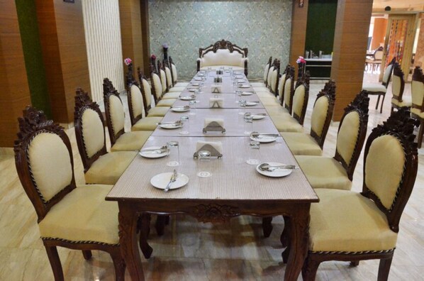 Una larga mesa de comedor con sillas, preparada para una comida.
