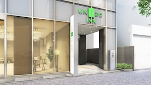 A modern hotel entrance with glass doors, a visible seating area inside, and a sign reading "UNIZO INN". - UNIZO INN Hiroshima Ekimae (Hiroshima)
