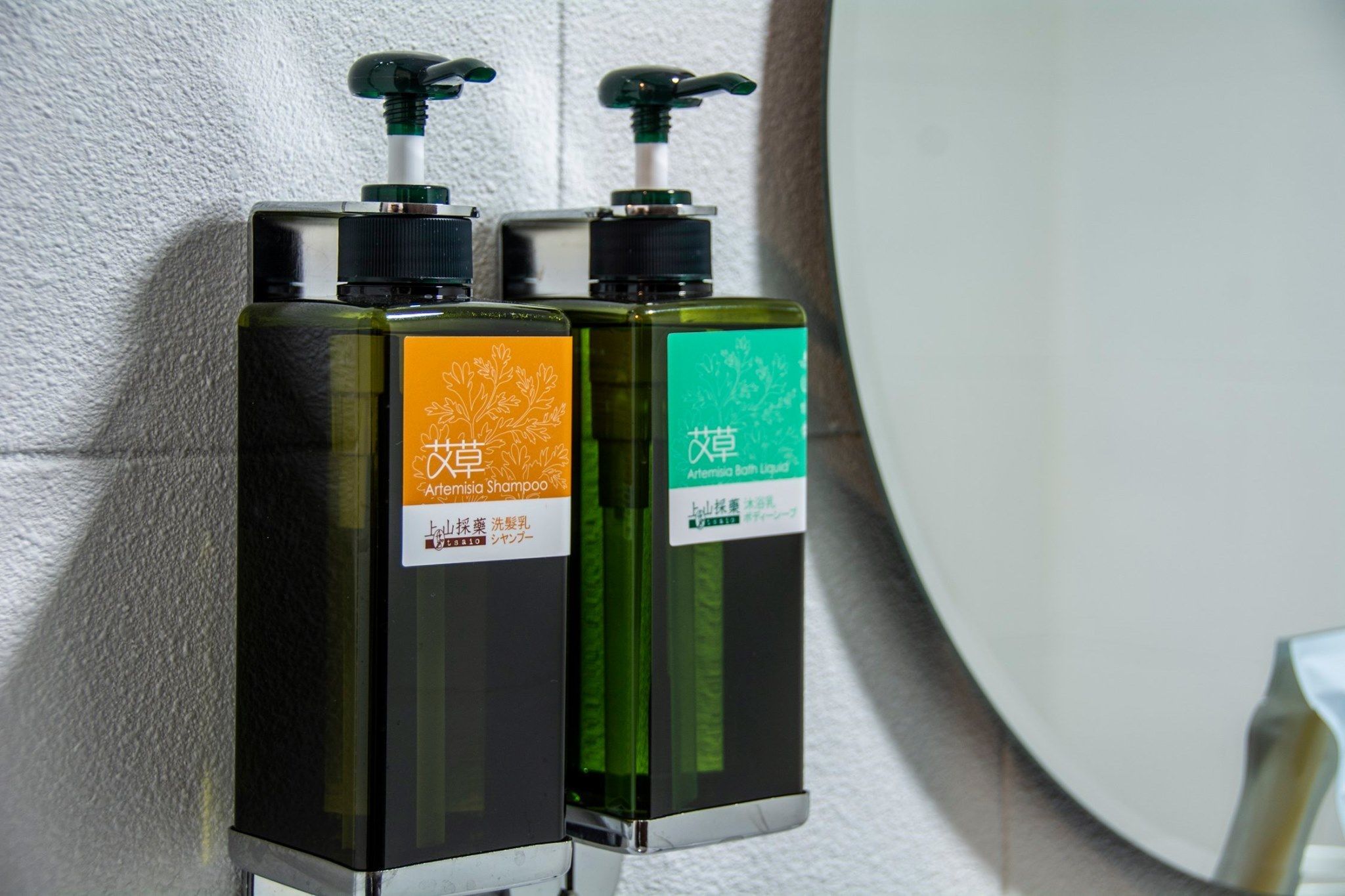 Deux bouteilles de shampoing à la sauge sont posées sur une étagère.