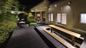 A wooden deck with a pool, surrounded by greenery and a building with large windows. - Kafutei (Yamaga)