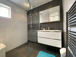 Een douche, handdoeken, toiletpapier