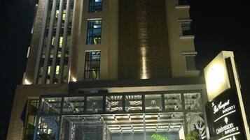 Ein Hotel mit einer modernen Fassade, beleuchteter Beschilderung und einem geschlossenem Eingangsbereich.