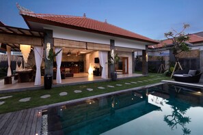 A modern house with a swimming pool, outdoor seating, and a well-maintained garden. - Villa Four Elements (Canggu)