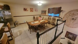 A dining area with a wooden table and chairs, a refrigerator, and a staircase with a railing. - Moondance lodge is a place you can go and relax and access the outdoors (Index)