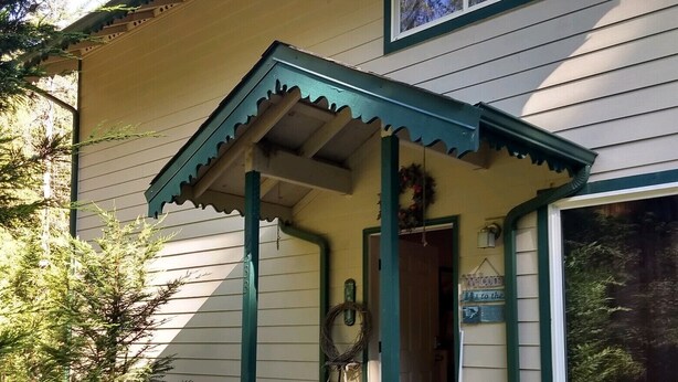 A house with a porch, a wooden staircase, and a stone wall. - Moondance lodge is a place you can go and relax and access the outdoors (Index)