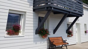 A white building with a balcony, a bench, and flower boxes. - Vacation cottage *** - Panoramic view - Sauna - Near lake - Mountain (Saulxures-sur-Moselotte)