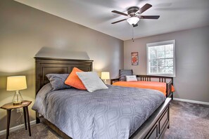 A bedroom with a bed, two bedside tables, a ceiling fan, a window, and a wall-mounted artwork. - Modern Home w/ Yard + Deck, 1 Mi to Clemson U! (Clemson)
