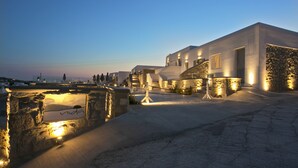 A modern building with stone walls and a paved area in front. - Nida Mykonos (Mykonos)