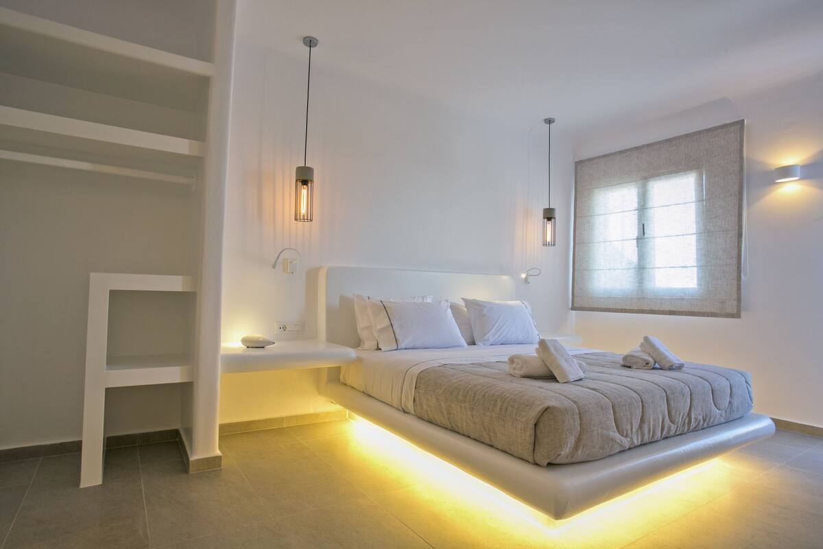 A modern bedroom with a built-in bed, bedside tables, and ambient lighting.