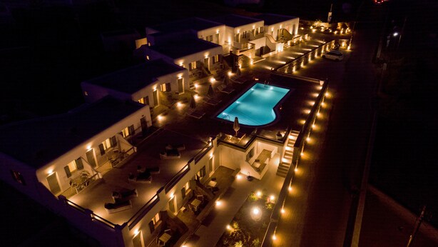 An aerial view of a hotel with a central swimming pool, multiple connected buildings, and outdoor seating areas. - Nida Mykonos (Mykonos)